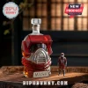 Red M.A.S.K. helmet glass whiskey decanter with a silver mask plaque on a wooden table next to a small pilot action figure.!