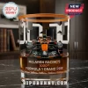 McLaren Racing 1000th Formula 1 Grand Prix whiskey glass with orange rim and race car graphic on marble surface.!