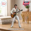 Elvis Presley action figure in white studded jumpsuit holding a sunburst electric guitar and gold microphone on desk.!