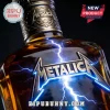 Metallica logo embossed on an amber glass whiskey bottle with blue lightning bolts against a black background.!