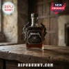 Metallica branded glass whiskey bottle with ornate pewter gothic wings and a black label on a rustic wooden table.!