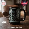 Black ceramic coffee mug featuring white Metallica logo, metal chains, a skull, and cross graphics on a wooden table.!