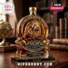 MGM 102nd anniversary gold-embossed whiskey decanter with a lion head emblem on a dark marble base, library background.!