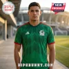Man wearing a green Mexico national soccer team jersey with black zig-zag patterns and red sleeve trim at a stadium.!