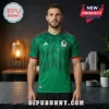 Man wearing a green Mexico national soccer team jersey with red trim and a graphic pattern, standing in a studio.!