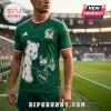 Man wearing green Mexico soccer jersey with Care Bear character, FIFA logo, and flag graphics in a stadium setting.!
