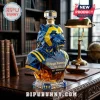 Michigan Wolverines faceted glass whiskey decanter with blue and yellow coloring on a dark wooden desk.!