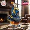 Michigan Wolverines mascot whiskey decanter in blue and yellow faceted glass with gold lettering on a stone surface.!