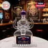 Clear glass Motörhead skull whiskey bottle with a purple crown stopper, sitting on a white table in a pub.!