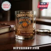 New York Knicks 2026 NBA Champions commemorative whiskey glass with a skyline graphic on a dark wooden desk.!