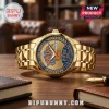 Gold-toned New York Knicks 2026 NBA Champions commemorative wristwatch on a wooden desk with notebooks.!