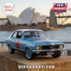 Blue Holden Torana diecast model car with NSW 1882 license plate parked before the Sydney Opera House at sunset.!