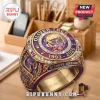 Oliver Tree tribute ring with gold finish, purple enamel, central portrait, and engravings reading 1993-2026 on a desk.!