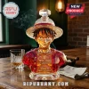 One Piece Luffy glass whiskey decanter with 30th anniversary text and straw hat design on a wooden bar table.!