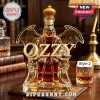 Ozzy Osbourne shaped glass decanter with gold-colored crown stopper filled with amber liquid on a wooden desk.!