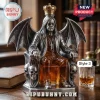 Ozzy Osbourne shaped glass decanter featuring metal wings, skulls, and a gold crown on a wooden desk with a whiskey glass.!