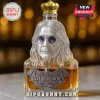 Clear glass decanter shaped like Ozzy Osbourne with a gold crown cap and metal bat label reading Rest in Power Ozzy.!