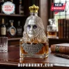 Ozzy Osbourne shaped glass liquor decanter with silver bust, gold crown stopper, and bat-shaped label on wooden desk.!