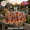 Custom shaped glass decanter spelling PAPA filled with amber whiskey, set on a stone wall with thistle and autumn leaves.!