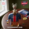 Glass whiskey decanter shaped like a blue soccer jersey with a UEFA Champions League trophy stopper on a wooden table.!