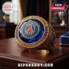 Gold Paris Saint-Germain F.C. championship ring featuring a central blue gemstone, red and blue accents, and 2026 text.!