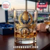 Clear whiskey glass with gold 2026 UEFA Champions League Paris Saint-Germain emblem and soccer trophy on wood table.!