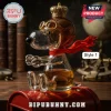 Clear glass Snoopy figure wearing a gold crown and aviator goggles, filled with amber liquid on a red metal mailbox.!