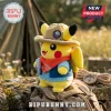 Pikachu plush toy wearing a safari hat and red bandana, sitting on a canvas backpack outdoors near a camping tent.!