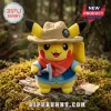 Pikachu plush wearing a tan explorer hat, red bandana, and blue vest, holding a small grey pickaxe on a mossy log.!