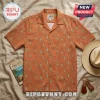 Orange short-sleeve button-up shirt with teal and beige diamond ikat pattern on a textured linen background.!
