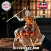 Rémy Martin centaur shaped glass cognac bottle filled with amber liquid held by hands in a dark interior setting.!