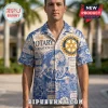 Man wearing a cream button-down shirt with blue vintage-style Rotary International graphics, globe, and service motifs.!