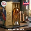 World Cup trophy shaped glass whiskey decanter inside gold display box on desk with globe and books in background.!