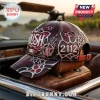 Maroon baseball cap featuring Rush band logo, 2112 text, and metallic silver web patterns on a vintage leather car headrest.!