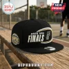 Black San Antonio Spurs 2026 NBA Finals snapback hat with white and gold embroidered lettering on a wooden bench.!