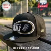 Black San Antonio Spurs 2026 NBA Finals snapback hat with white and gold embroidered oval logo on a wooden bench.!