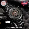 Black metal analog wristwatch featuring a Slayer band logo, eagle emblem, and tachymeter bezel on a dark textured surface.!
