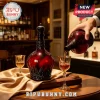 Deep red glass decanter with ornate black relief detailing and matching stopper pouring whiskey into crystal glasses.!