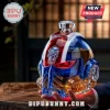 Glass skull helmet decanter with blue and red panels, metallic skull emblem, and clear crystal stopper on wooden table.!