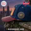 Navy blue baseball cap with a maroon leather brim, metallic gold Spider-Man logo patch, and NYC skyline background.!