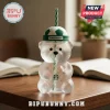 Clear bear-shaped glass tumbler with green and white soccer ball lid, straw, and Starbucks logo on a wooden desk.!