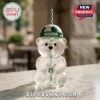 Clear glass bear-shaped tumbler featuring a Starbucks logo, green soccer ball lid, and green striped straw on a table.!