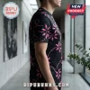 Man wearing a black short-sleeved t-shirt with a pink floral pattern and subtle dark grey geometric background prints.!