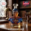 Superman-shaped glass decanter with crystal stopper on a wooden desk, displaying the iconic chest logo and blue suit color.!