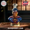 Superman character glass decanter with crystal stopper on a wooden table, featuring blue, red, and gold faceted details.!