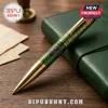 Green patterned ballpoint pen with gold trim, featuring a round Teenage Mutant Ninja Turtles emblem on a wooden desk.!