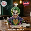 Joker bust whiskey decanter made of multifaceted green and purple glass featuring Agent of Chaos text on a wooden table.!