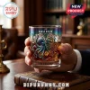 Kraken whiskey glass featuring an iridescent octopus and sailing ship design filled with amber liquid and ice cubes.!