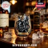 Kraken Black Spiced Rum glass featuring octopus illustration and logo on a wooden bar top with ice cubes.!