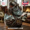 Octopus-shaped glass decanter holding a miniature bottle of The Kraken Black Spiced Rum on a wooden desk with a compass.!